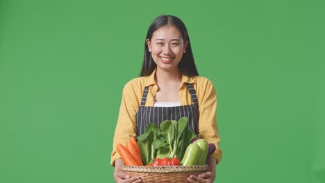 woman holding a basket of fresh vegetables