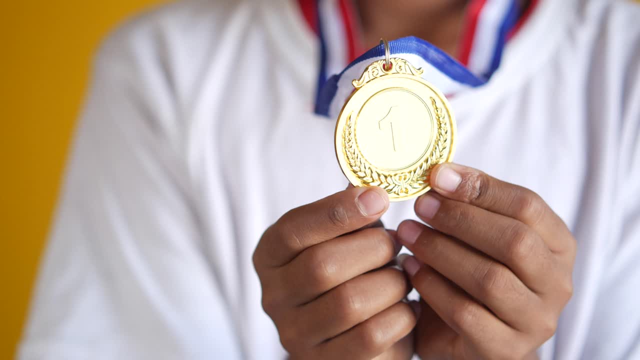 Child holding a gold medal