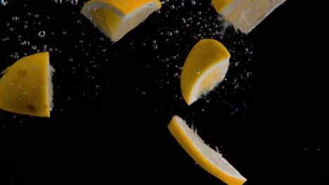 lemon pieces and slices falling into water super slowmotion, black background, lots of air bubbles, 4k240fps