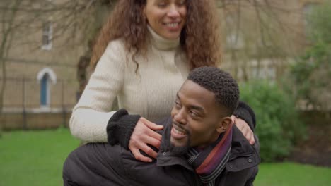 man gives woman piggy back ride