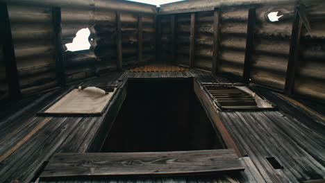 abandoned, broken zinc roofed triangle log cabin