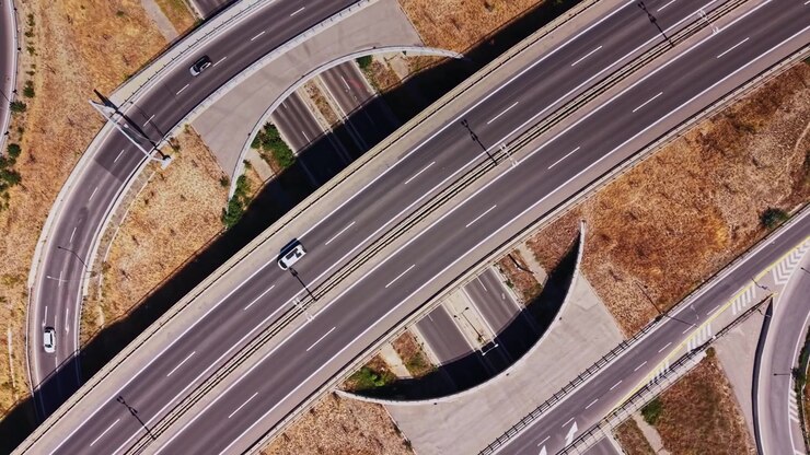 Highway interchange viewed from above with road and vehicles