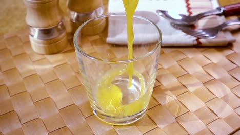 Orangensaft-In-Ein-Glas-Gießen,-Das-Morgendliche-Frühstück.-Zeitlupe-Mit-Rotierender-Kamerafahrt.