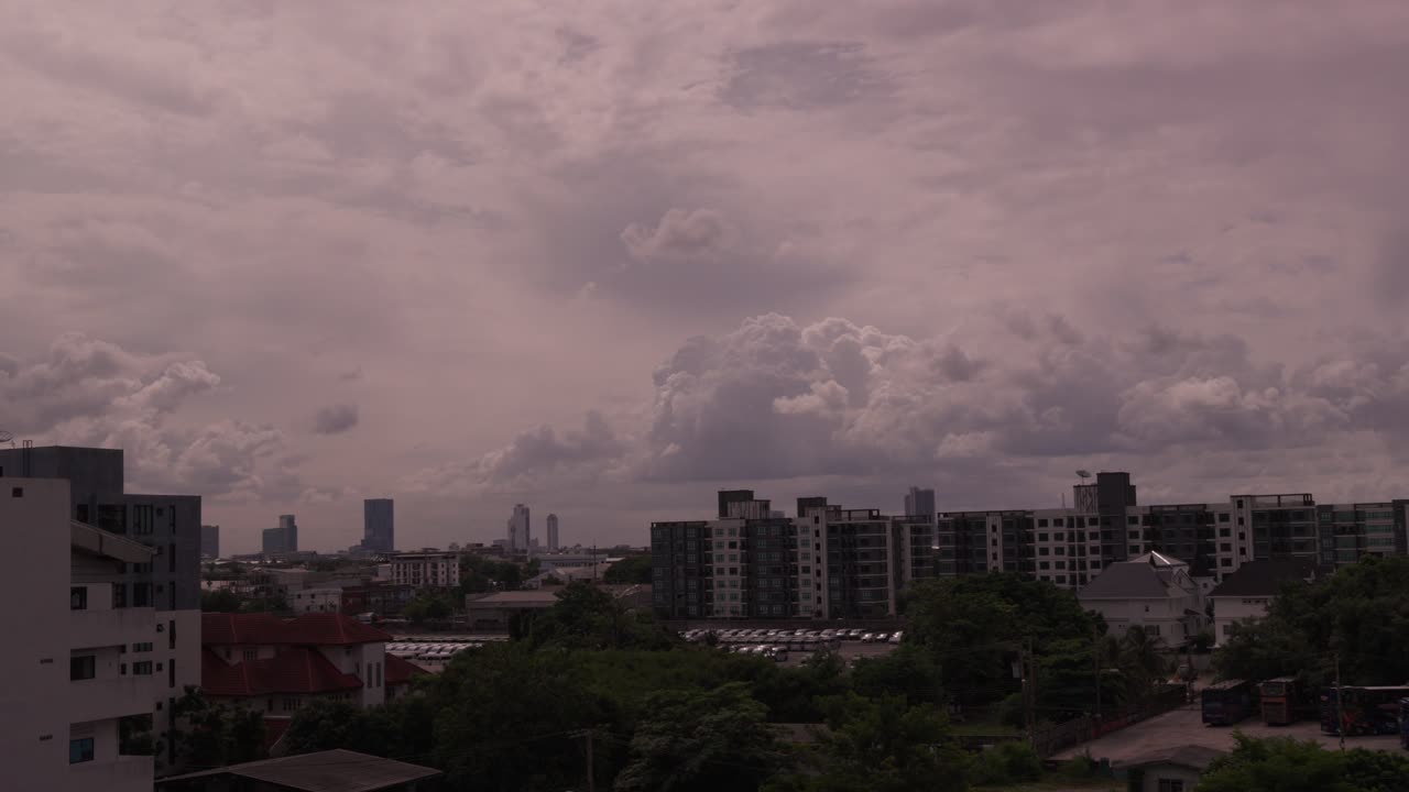 Skyline of Bangkok in a time-lapse shot, showing urban buildings and dramatic clouds