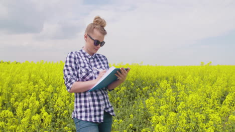 granjera con gafas escribe notas en el campo