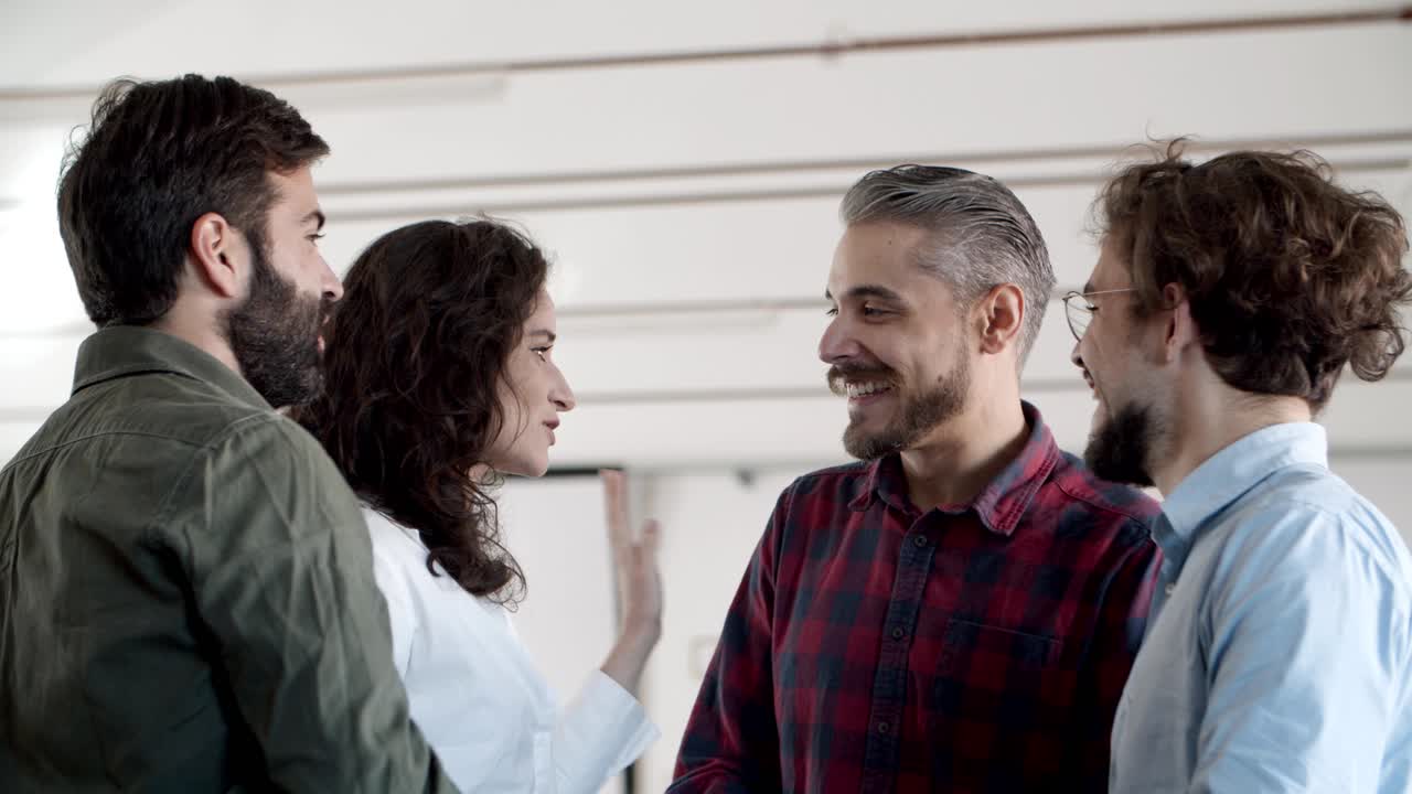 compañeros de trabajo jóvenes sonrientes hablando y dando cinco altos