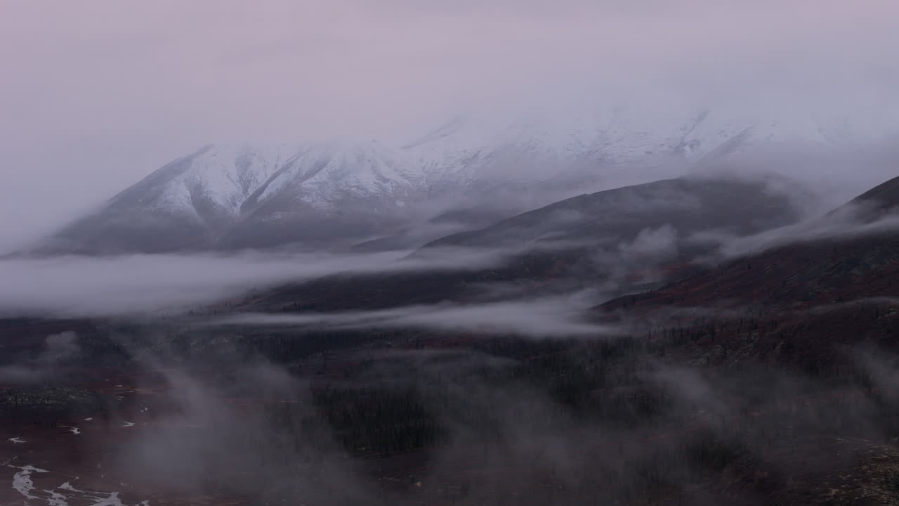 Snowy Ogilvie Mountains With Fog Clouds In Yukon Territory, Canada. wide shot