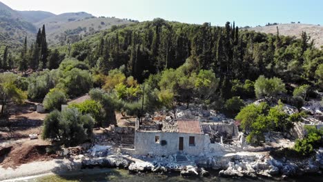 ancient ruins at the rugged coast of agia sofia beach in greece - aerial pullback shot