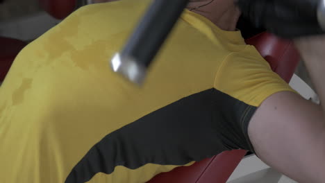 sportman die zijn borstspieren buigt op een gymmachine