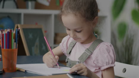young girl drawing at desk