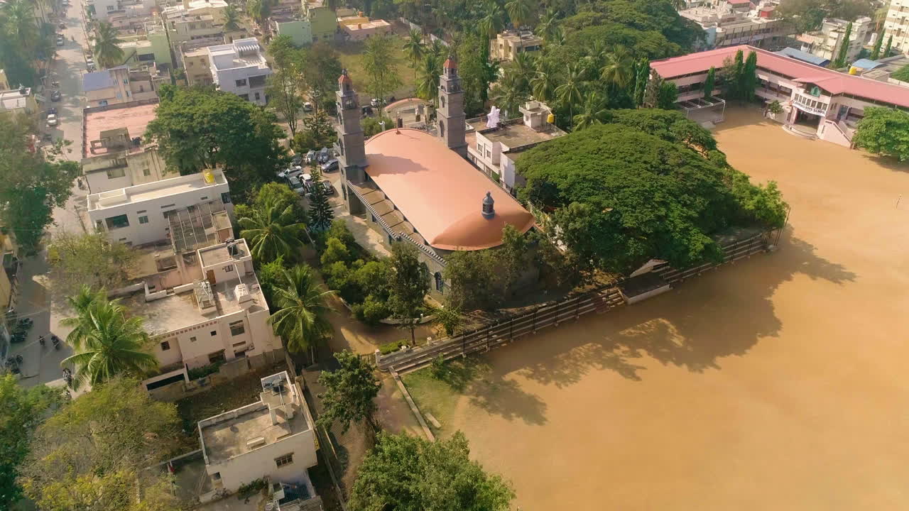 Davanagere church surrounded by trees and nearby buildings on a sunny day, aerial view, Karnataka India