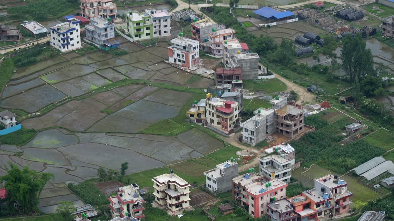 A panning aerial view of the city of Kathmandu, Nepal on a cloudy day at the beginning of rainy season
