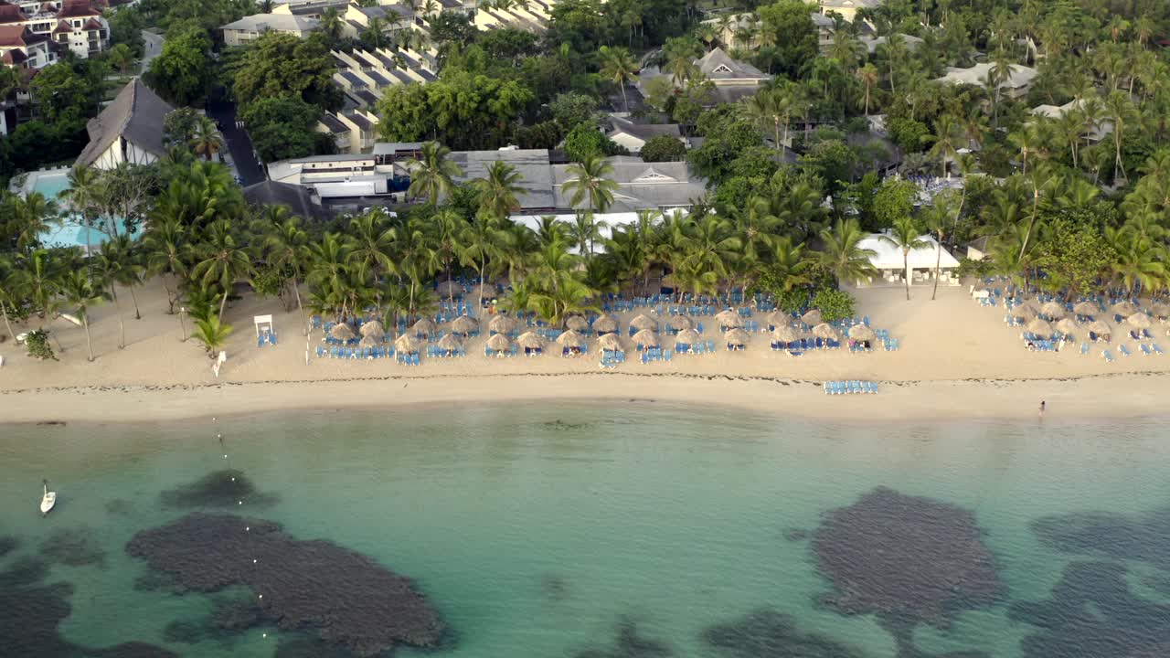 vista de drones del océano, sombrillas y playa de arena caribeña, playa grand bahia principe en la península de samana, república dominicana
