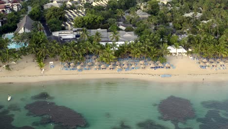 Drohnenblick-Auf-Das-Meer,-Sonnenschirme-Und-Den-Sandstrand-Der-Karibik,-Grand-Bahia-Principe-Beach-Auf-Der-Halbinsel-Samana,-Dominikanische-Republik