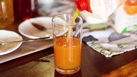 orange juice being poured into a glass