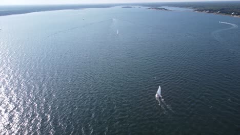 Sailboat-Sailing-in-seawater-by-coastline-in-Massachusetts