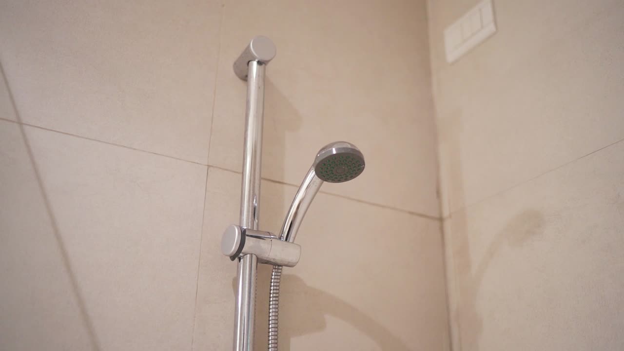 Shower head mounted on tiled bathroom wall in a modern household setting, Patagonia, Argentina.