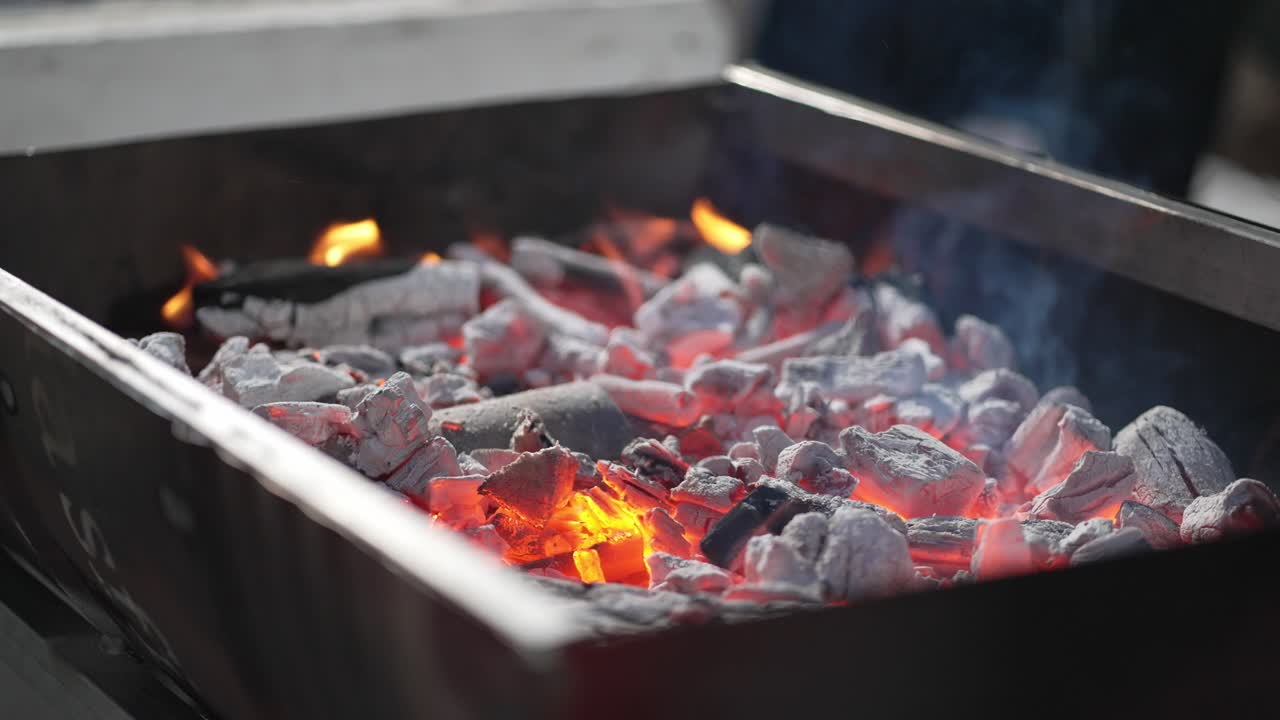 Hot coals and flames in a barbecue pit