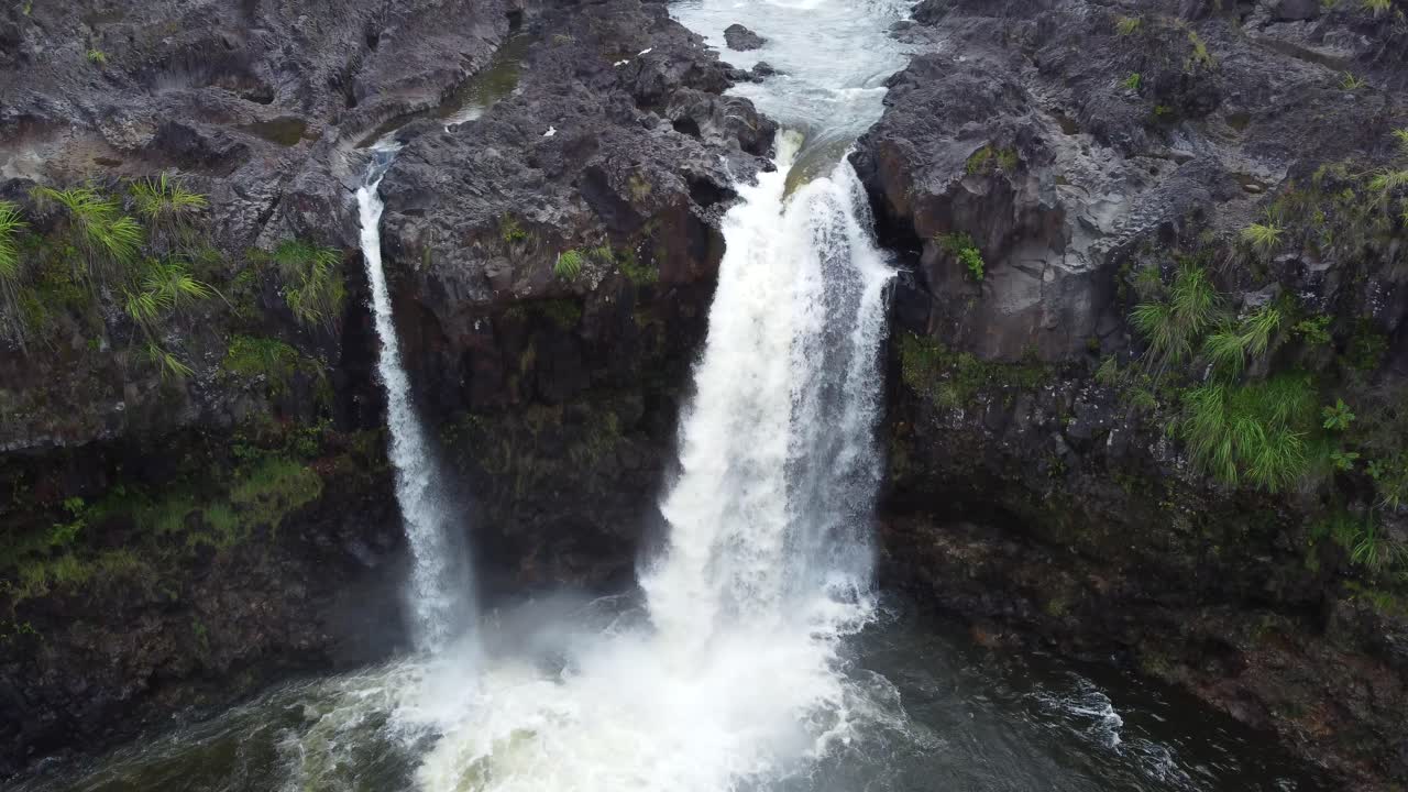toma de drone de grúa cinematográfica de 4k de una cascada que se precipita sobre un acantilado en una selva tropical cerca de hilo en la isla grande de hawaii
