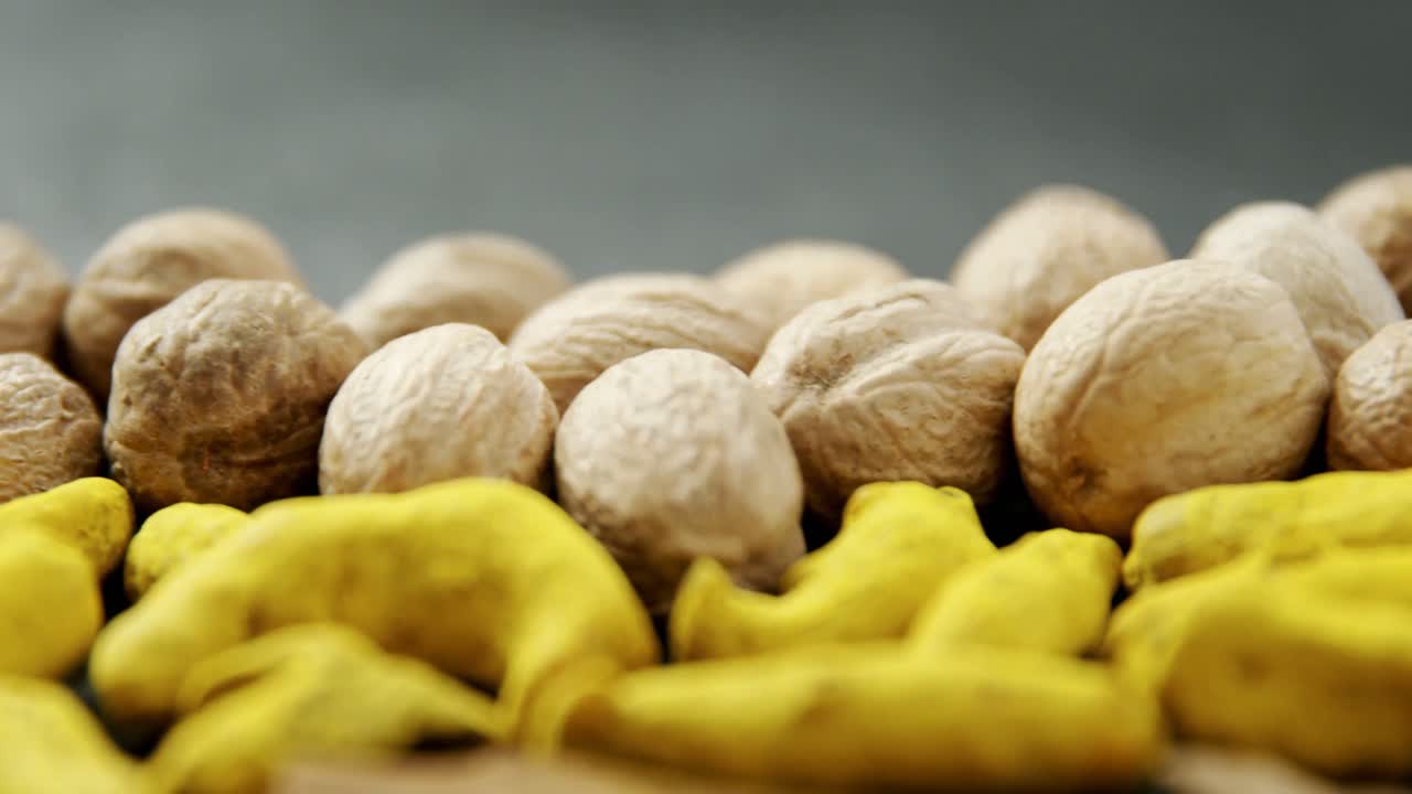 Noce moscata e bastoncino di curcuma su sfondo nero 4k