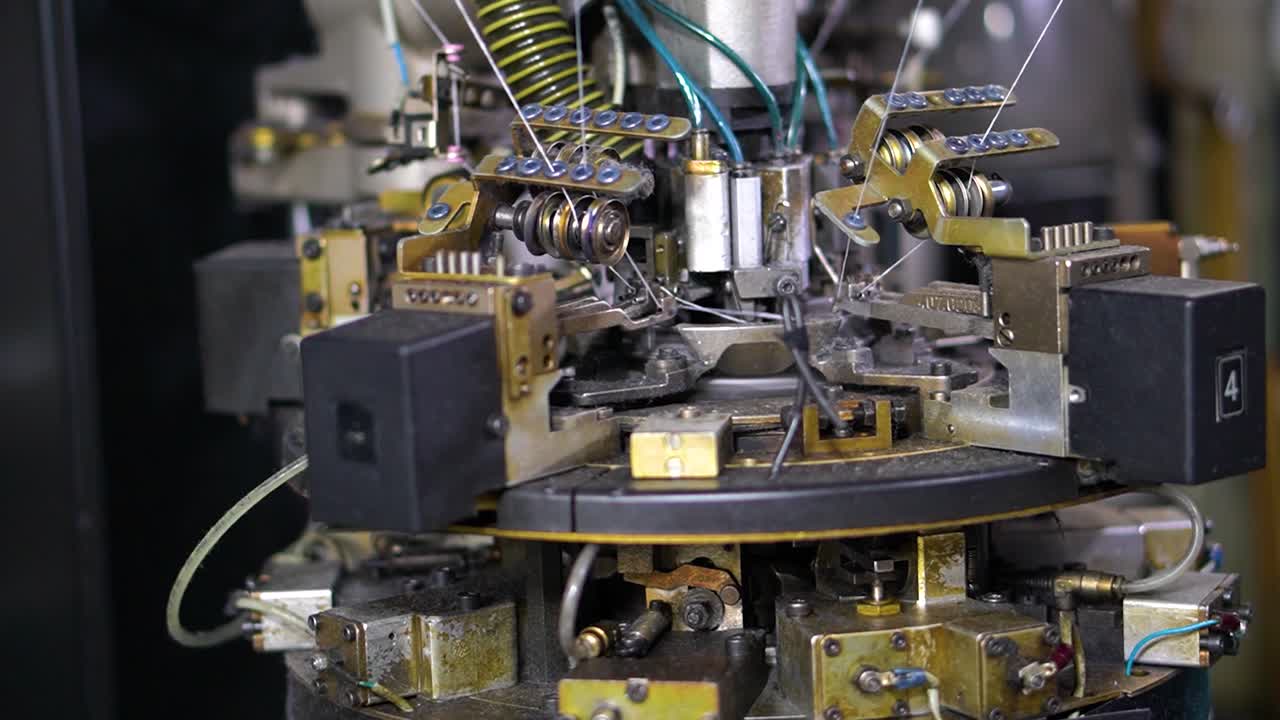 partes cercanas de la máquina con hilos que producen prendas de vestir