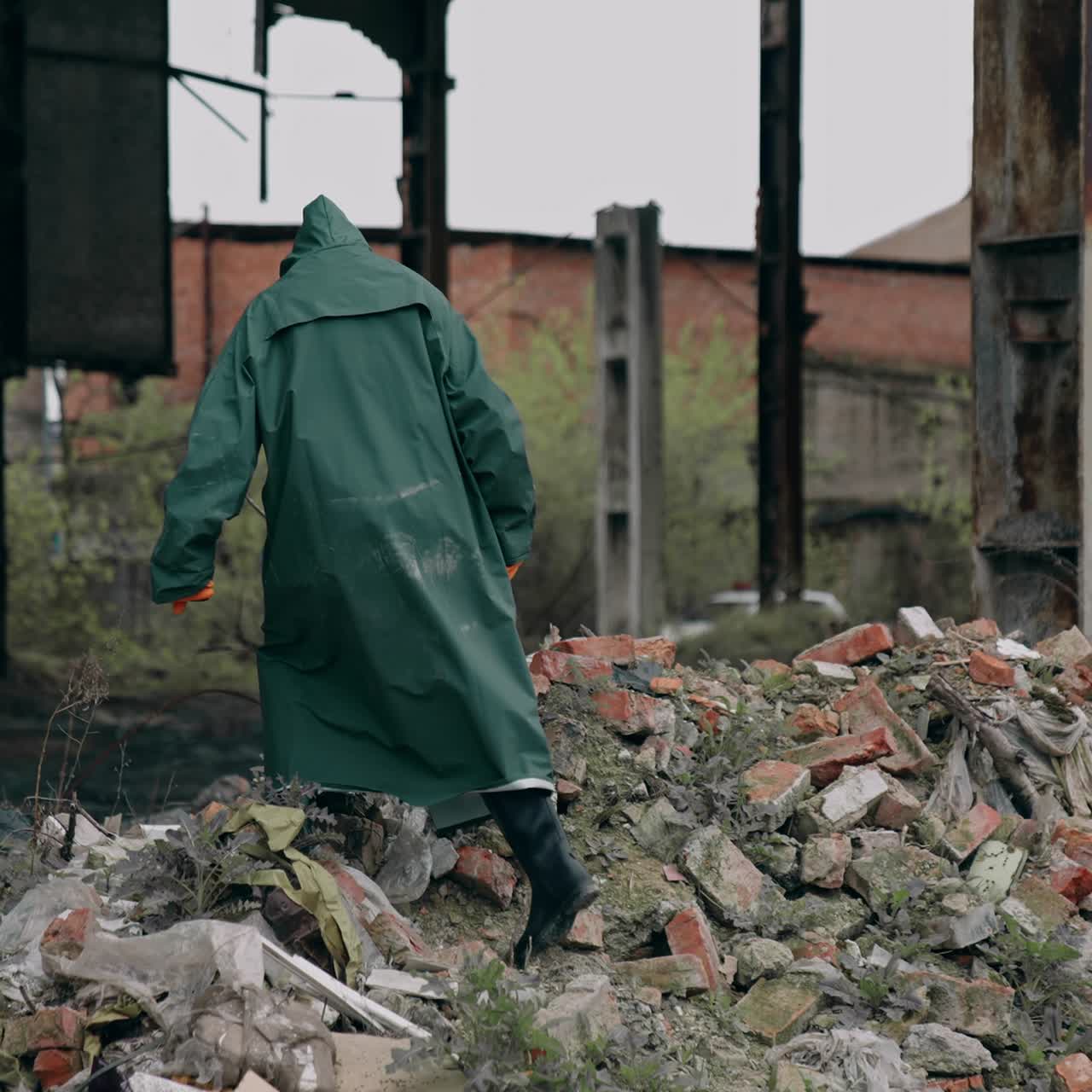 Survivor in destructed place. Human in protective clothing and respirator standing on a pile of garbage in abandoned place. High level of radiation
