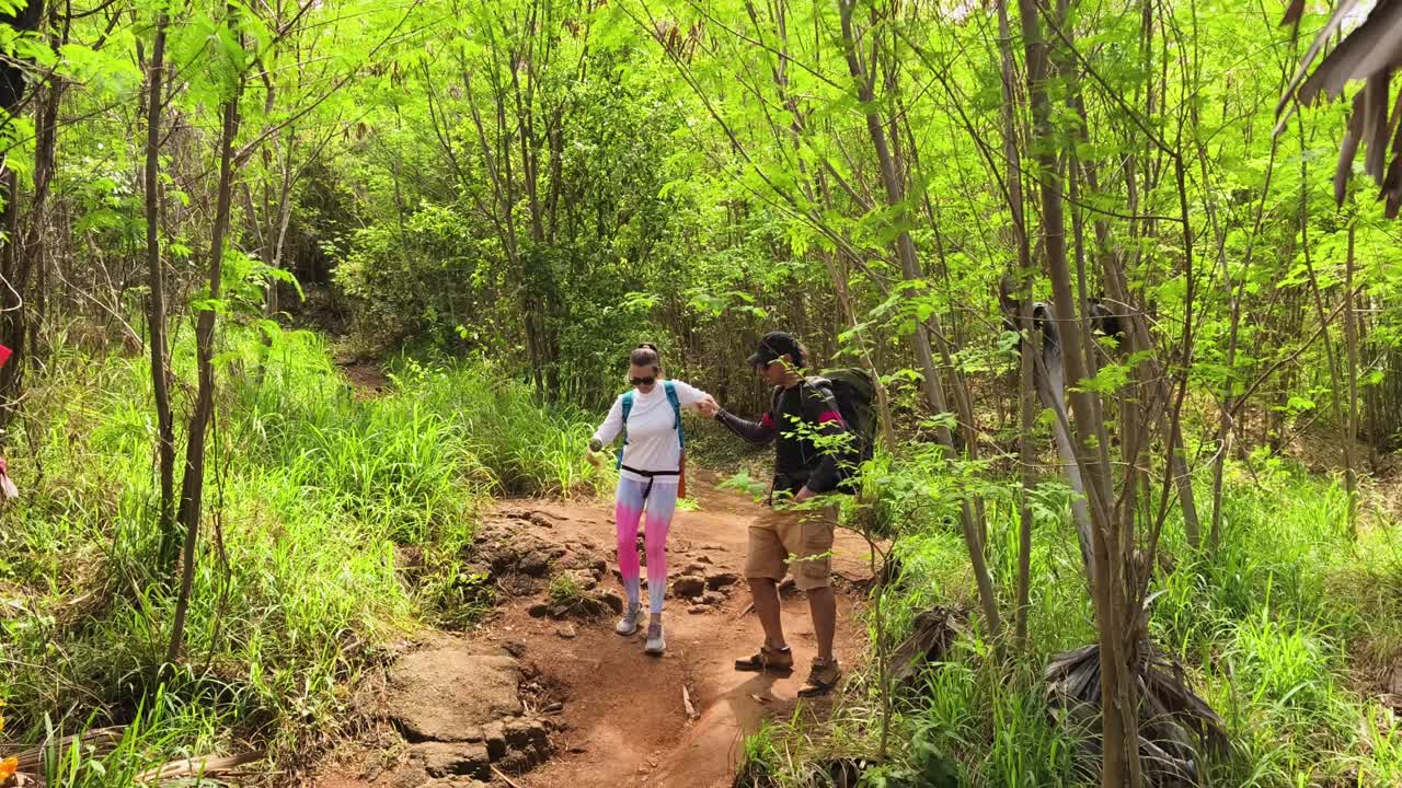 부부 가 울창 한 숲 에서 산책 하고 있다