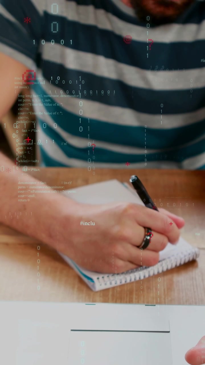 Vertical video: Coder typing on laptop and using trackpad, showing code overlay while writing notes