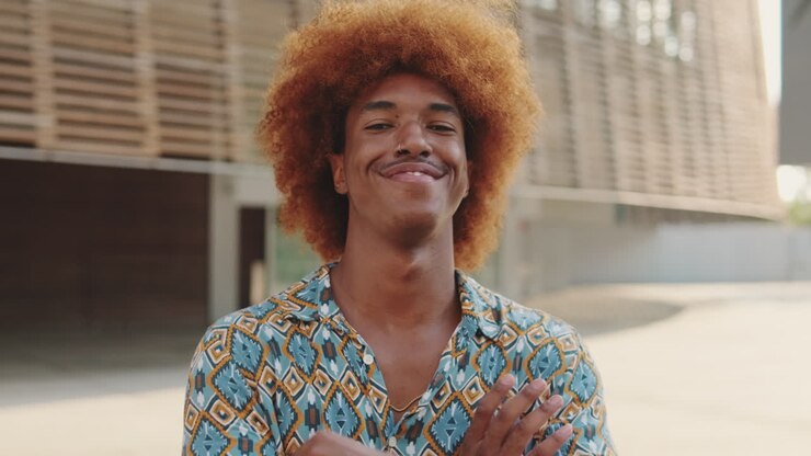 Young Man with Afro Hairstyle Smiling and Crossing Arms