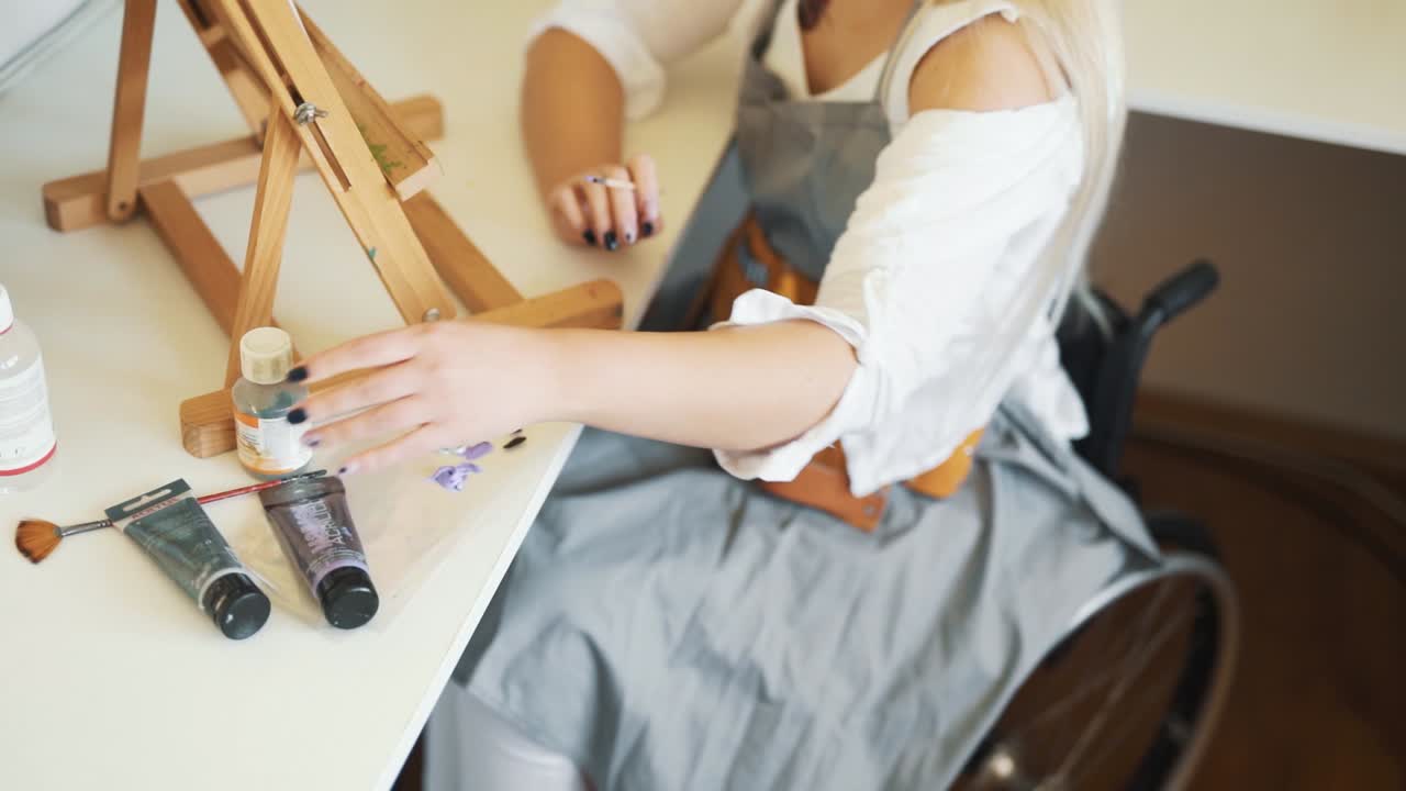 close-up of female hands drawing a picture of a woman sitting in a wheelchair