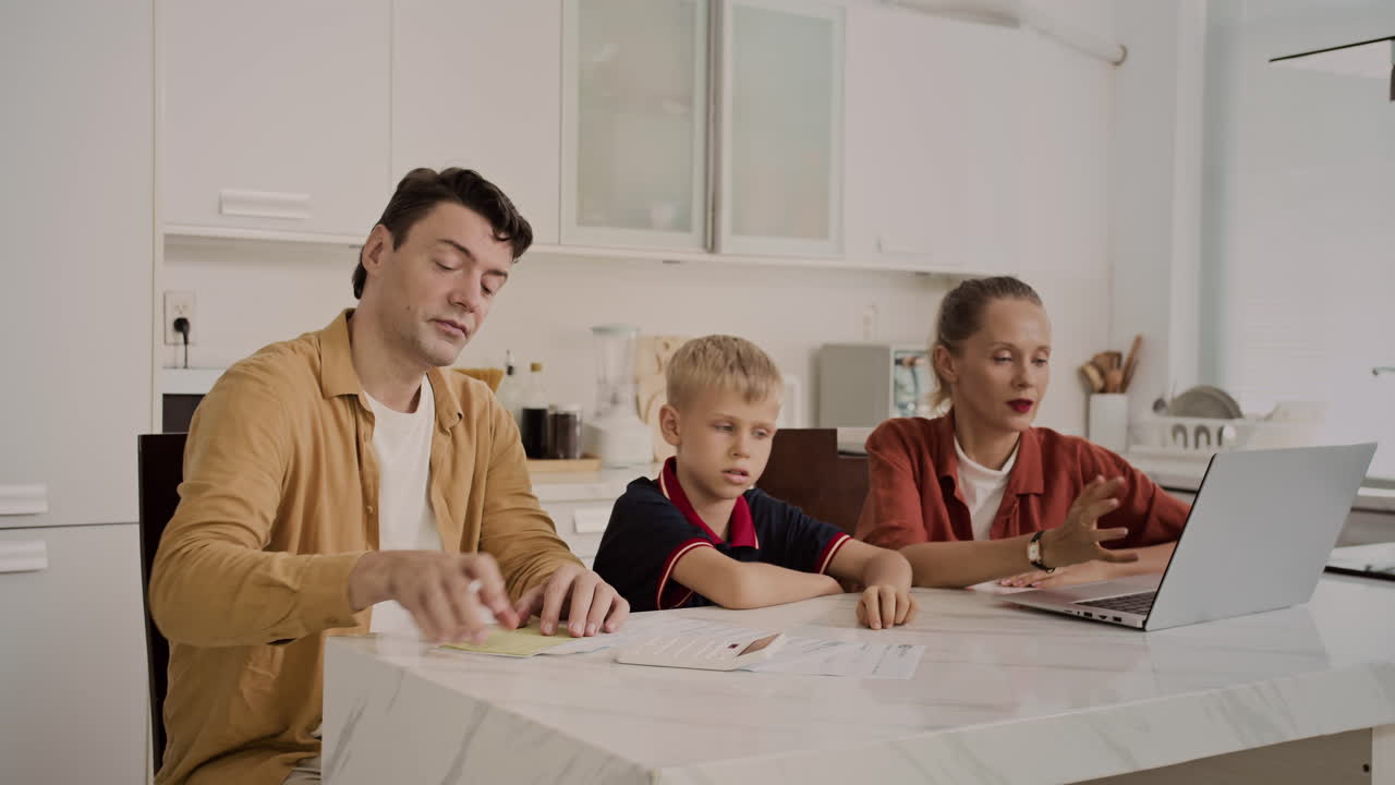 Spouses and Their Sun Paying Online for Bills at Home Kitchen
