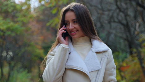 woman talking on phone in autumn park