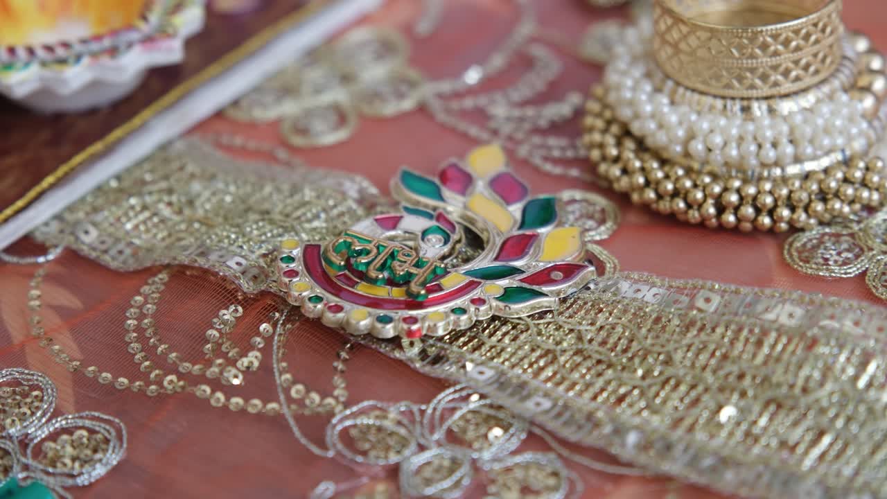 Close-up of a vibrant Indian Rakhi bracelet placed on a table, ready for a wedding ceremony, highlighting traditional South Asian jewellery and festive cultural preparations