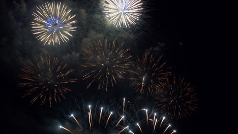 cielo nocturno lleno de fuegos artificiales, espectaculares explosiones pirotécnicas, celebración navideña
