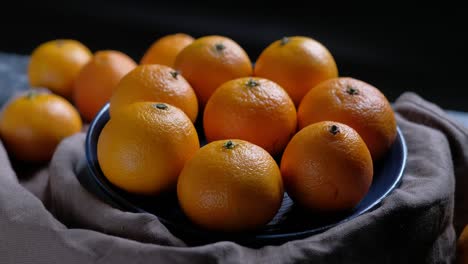 pile of unpeeled round ripe orange mandarin in a plate