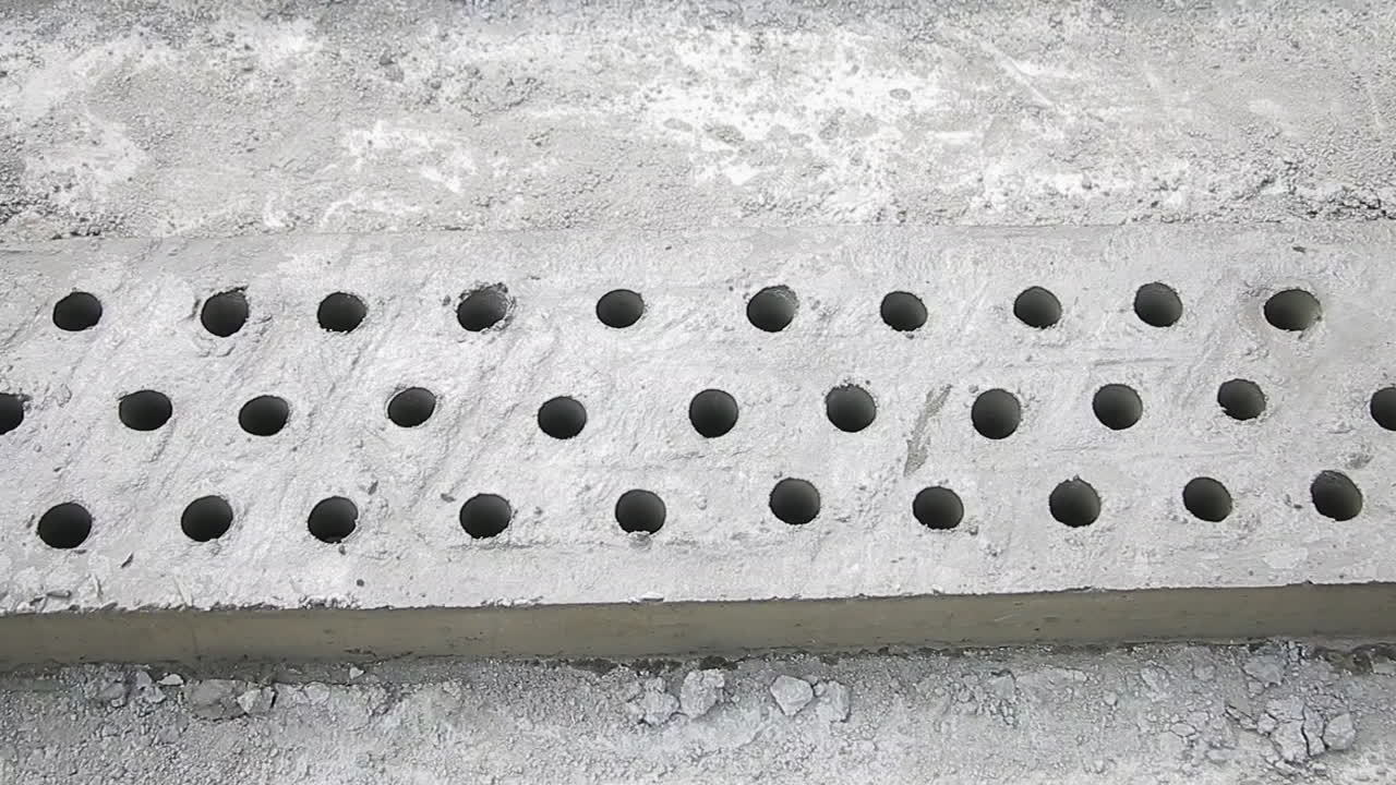 Perforated concrete slab with evenly spaced holes, ready for installation