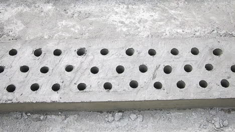 perforated concrete slab with evenly spaced holes, ready for installation