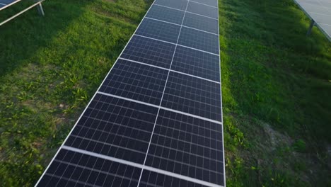 Paneles-Solares-En-Un-Campo-Verde-Bajo-La-Luz-Del-Sol,-Vista-Aérea