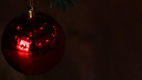 conceptual video of twinkling lights reflected on a red christmas ball ornament against a dark background