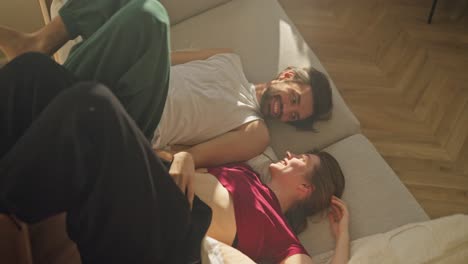 una pareja feliz relajándose en un sofá.