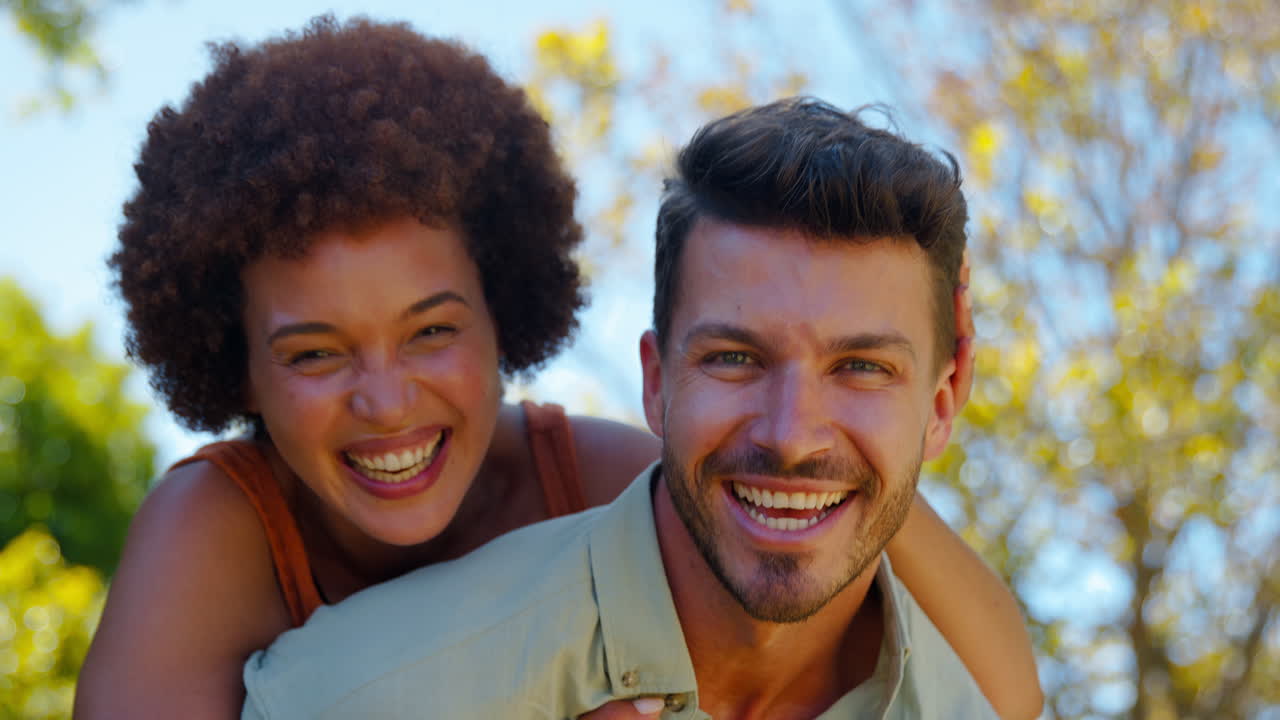 Portrait Of Loving Multi-Racial Couple With Man Giving Woman Piggyback Outdoors In Garden
