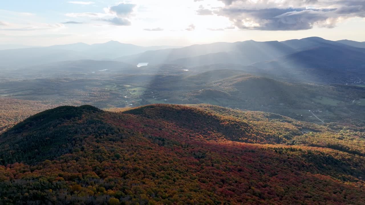 aerial of mount mansfield with the suns rays in fall and autumn near Stowe Vermont