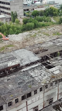 flying over abandoned industrial factory buildings in very dilapidated condition. old building for demolition.. vertical video