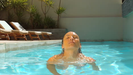 woman emerging from swimming pool