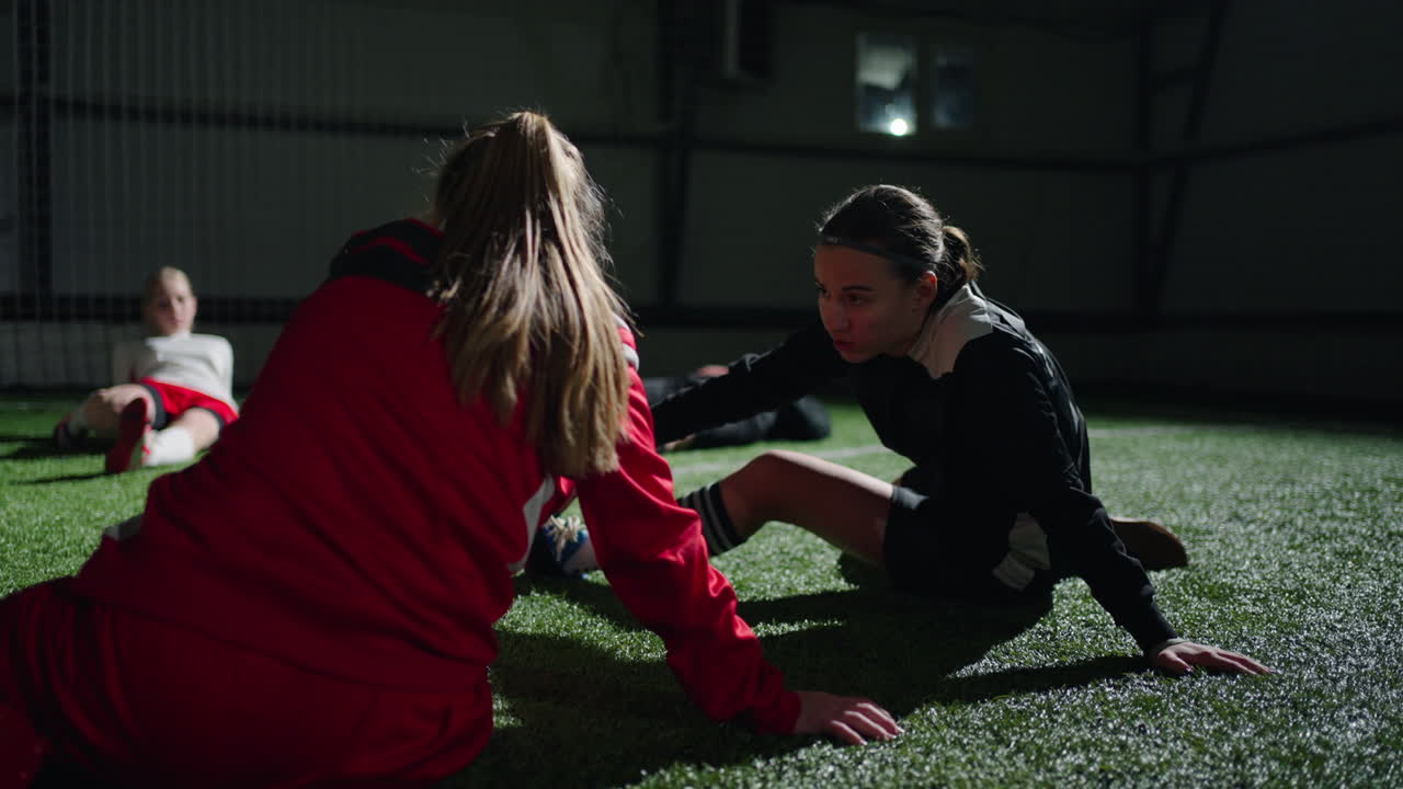 молодые футболистки растягиваются перед игрой