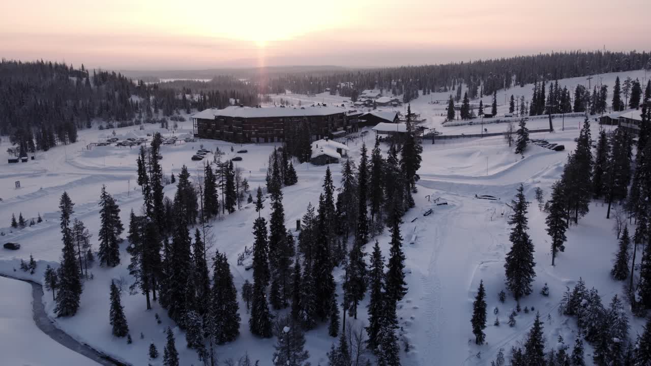 Droneskudd soloppgang over Ruka skianlegg og fjell i Lappland