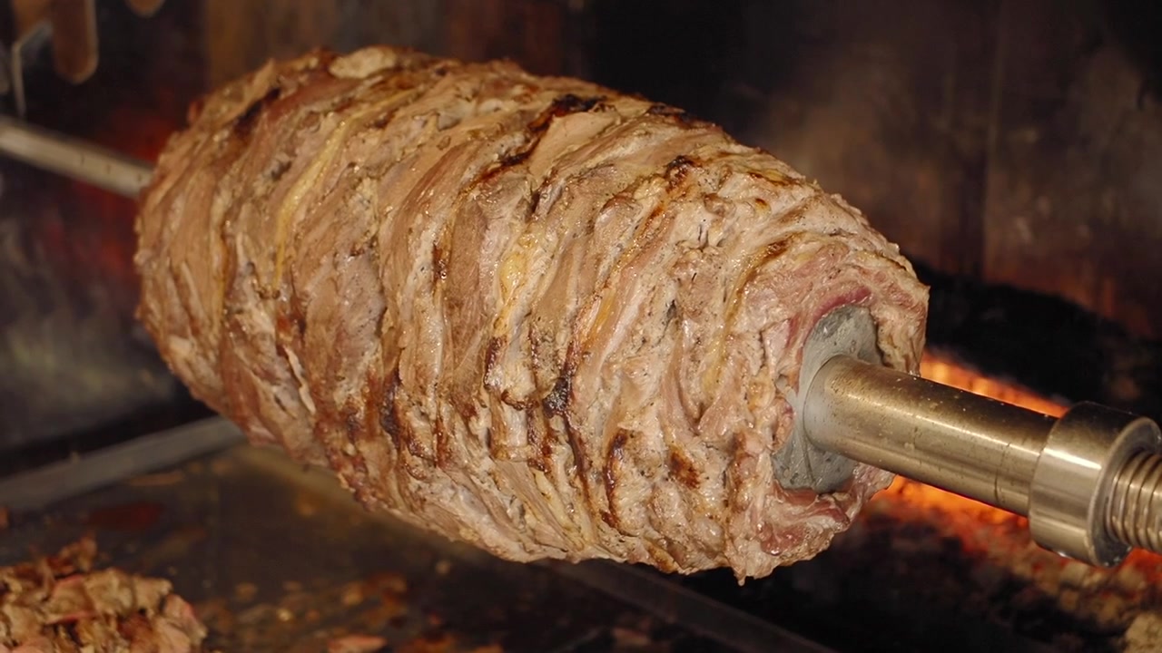 Carne di doner kebab che ruota su uno spiedo verticale