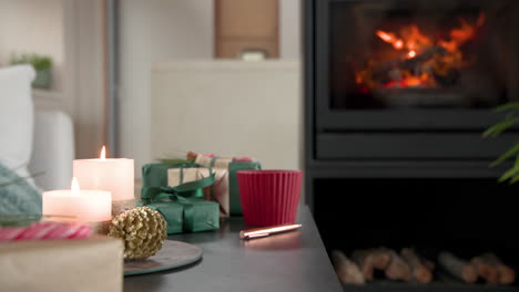 cozy christmas scene with candles, gifts, and fireplace creating warm ambiance, copy space