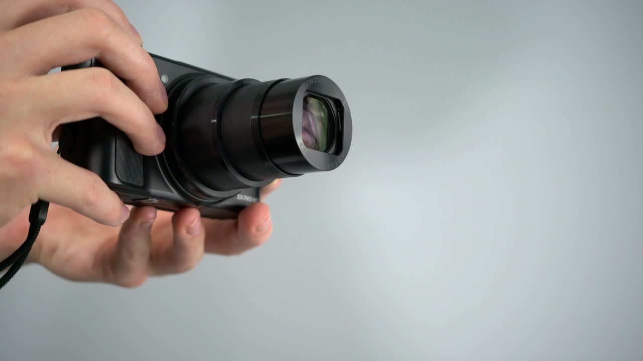Utilizzo, zoom e scatto di foto con una piccola fotocamera compatta super zoom Canon, scatto in studio con sfondo bianco