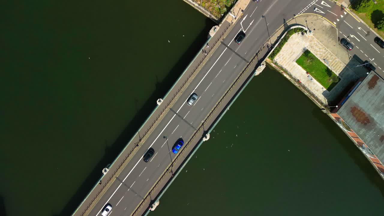 Overhead rising aerial GV of traffic on Queen's Bridge in Belfast City Centre, Northern Ireland, UK on a bright and sunny day. Produced in 4K, 60FPS and with Rec709 color
